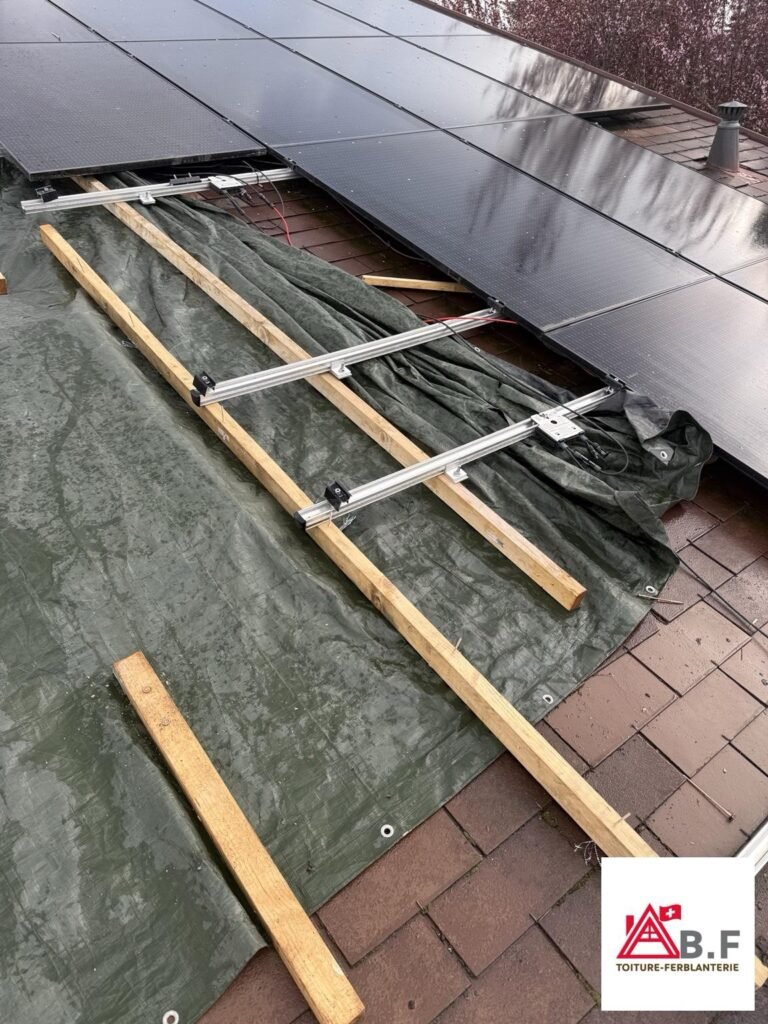 Protection provisoire de toiture avec bâche sous panneaux photovoltaïques à Borex dans le canton de Vaud pour sécuriser la toiture avant rénovation.